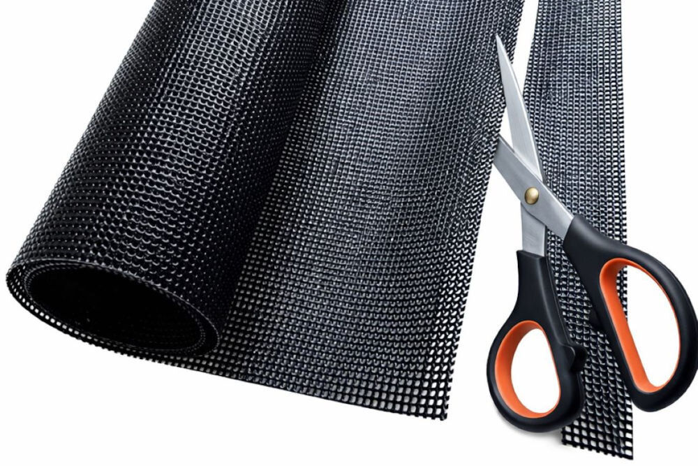 Mata ochronna na płytę indukcyjną LEXPERTO Rolka czarnej maty siatkowej o strukturze plastra miodu przecinana nożyczkami w celu dopasowania rozmiaru.