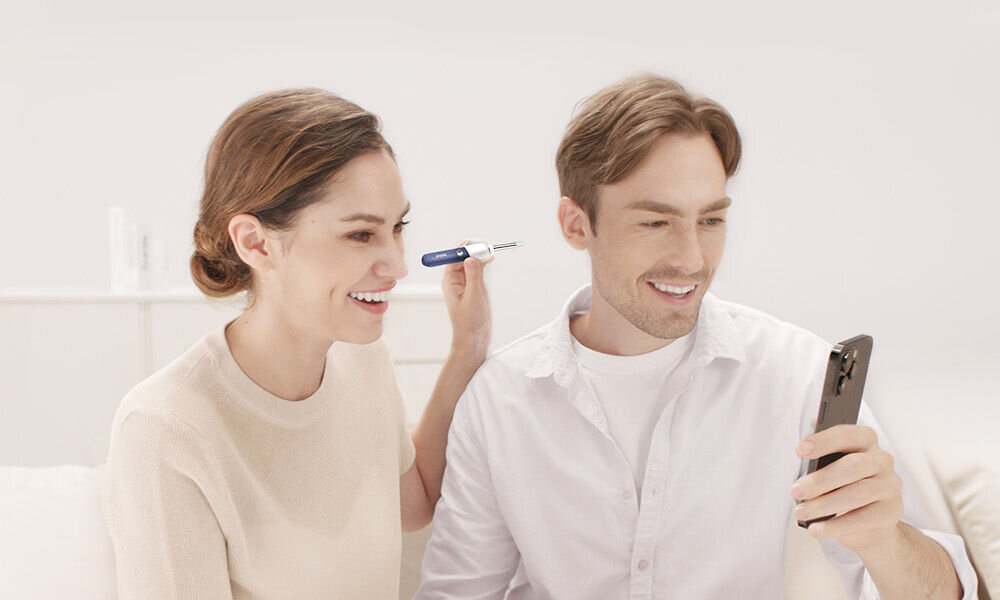 Otoskop do uszu z kamerą BEBIRD Earvision Plus I35R dwie osoby patrzące w ekran telefonu jedna z nich trzyma urządzenie przy uchu drugiej