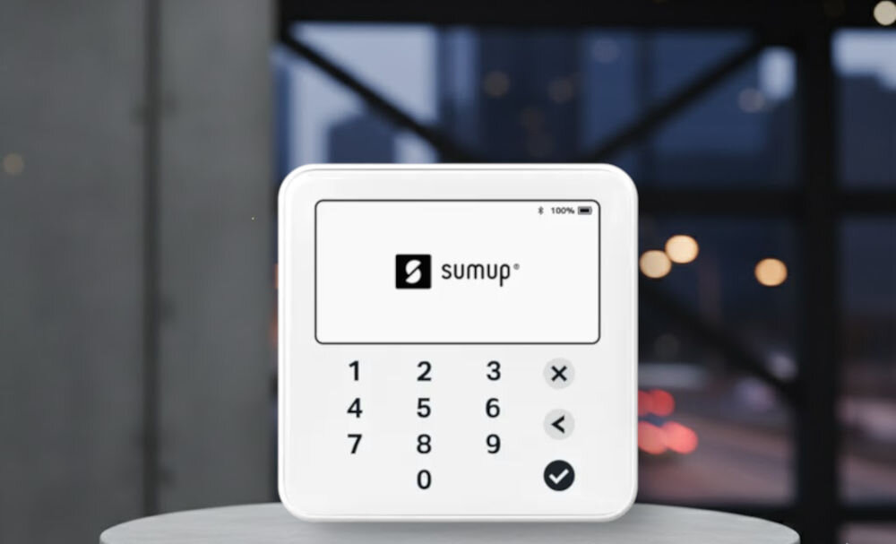 Terminal płatniczy SUMUP Solo Lite Bluetooth prezentacja urządzenia na podeście na tle wieżowca i miasta do 1000 na jednym ładowaniu mobilność