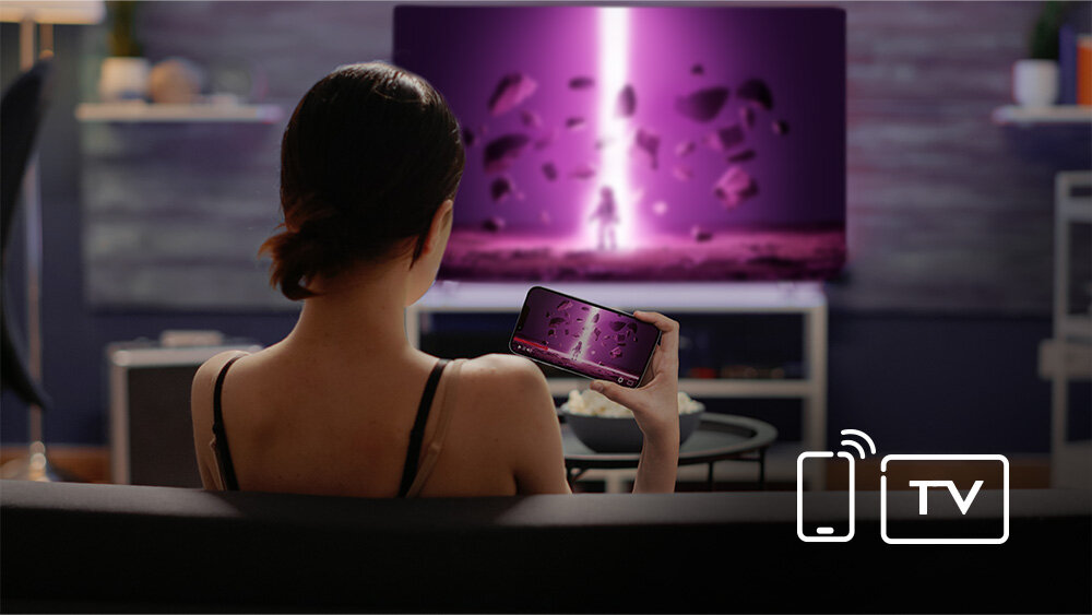 Telewizor JVC LT-43VDQ3500 - Bezprzewodowe przesyłanie treści z telefonu, kobieta trzyma smartfona w ręku, który przesyła obraz do telewizora