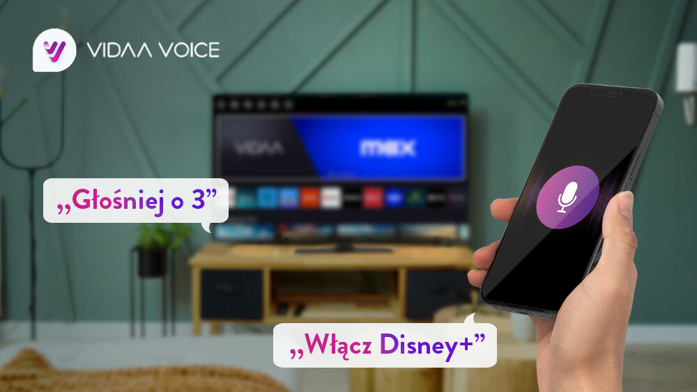 Telewizor JVC LT-43VDQ3500 - Steruj głosowo z VIDAA Voice, telewizor stojący w salonie na stoliku, na pierwszym planie jest ręka z telefonem przedstawiający sterowanie głosowe