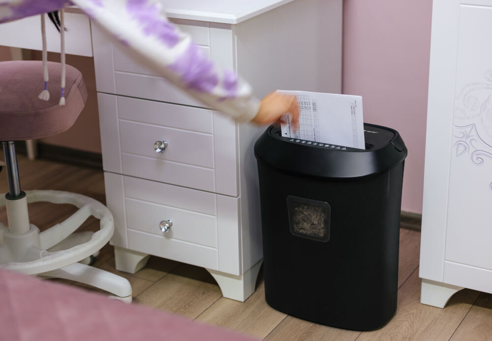 Niszczarka TRACER FileCrusher prezentacja niszczarki podczas korzystania osoba wkładająca papier do niszczarki stojącej przy biurku w pokoju małe biura bezpieczeństwo informacji karty kredytowe nośniki danych ochrona poufnych dokumentów