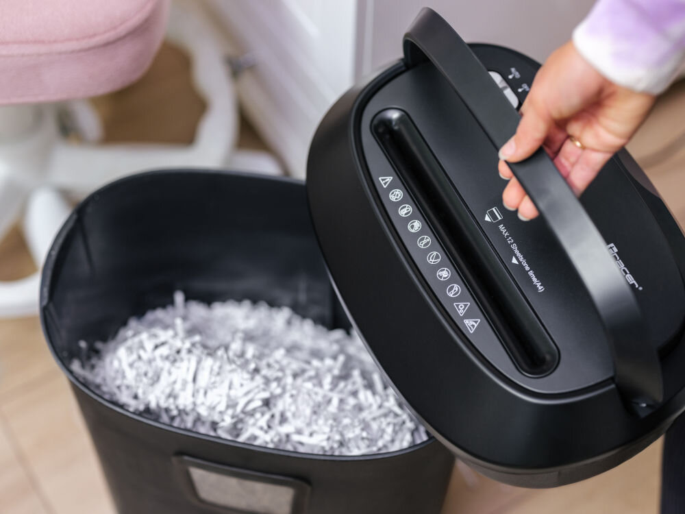 Niszczarka TRACER FileCrusher prezentacja niszczarki zbliżenie na otwartą pokrywę trzymaną w dłoni w pokoju system zabezpieczenia przed przegrzaniem zintegrowany uchwyt wygoda obsługi