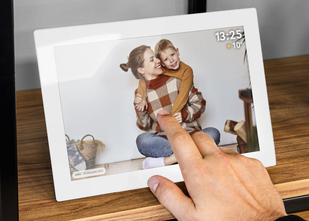 Ramka cyfrowa KRUGER&MATZ KM1100W Frameo 10.1 cala Biały prezentacja ramki ze zdjęciem i komentarzem do niej na regale palec dotykający ramkę 10 calowy ekran rozdzielczość IPS komfortowe przeglądanie