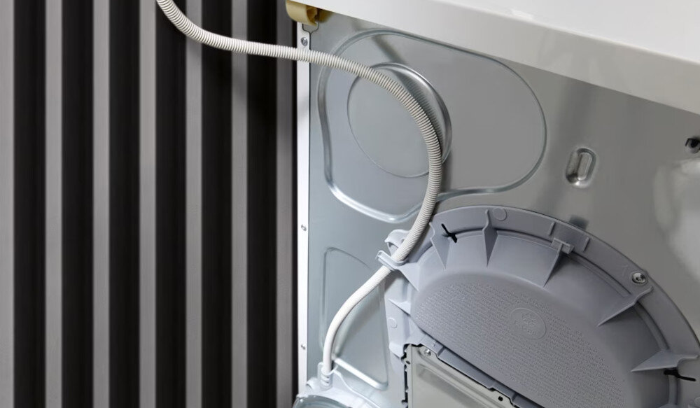 Suszarka MIELE TWD640WP EcoSpeed zdjęcie wizualizacyjne lifestyle tył suszarki wąż przyłącza Wygodne odprowadzanie wody kondensacyjnej zwijacz węża do umywalki syfonu