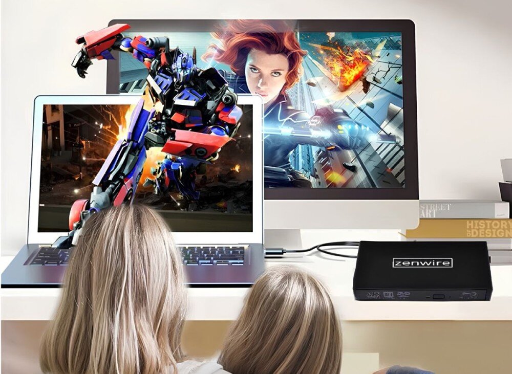 Napęd ZENWIRE SY886 Dwoje dzieci siedzi przed laptopem i monitorem, na których wyświetlana jest scena akcji z filmu. Napęd optyczny jest podłączony do komputera i leży na biurku, przeznaczenie, działanie, płyty CD i DVD