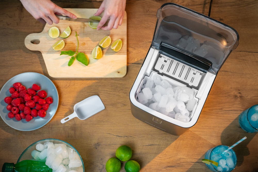 Kostkarka do lodu GOTZE & JENSEN IM500K Czarny widok z góry na otwartą kostkarkę obok łopatka owoce i drinki