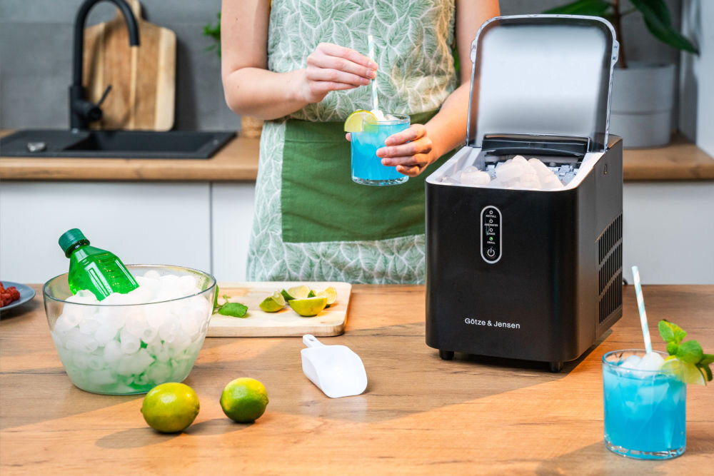 Kostkarka do lodu GOTZE & JENSEN IM500K Czarny otwarta kostkarka z pełnym zbiornikiem lodu wokół owoce drinki i butelka w misce z lodem