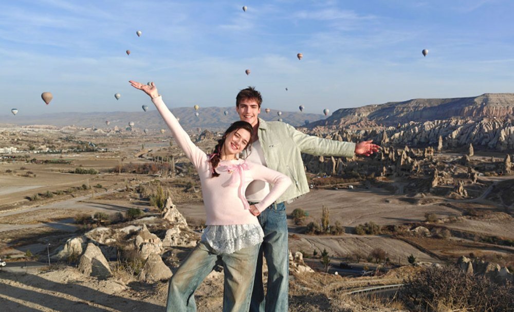 Para na tle gór i unoszących się balonów