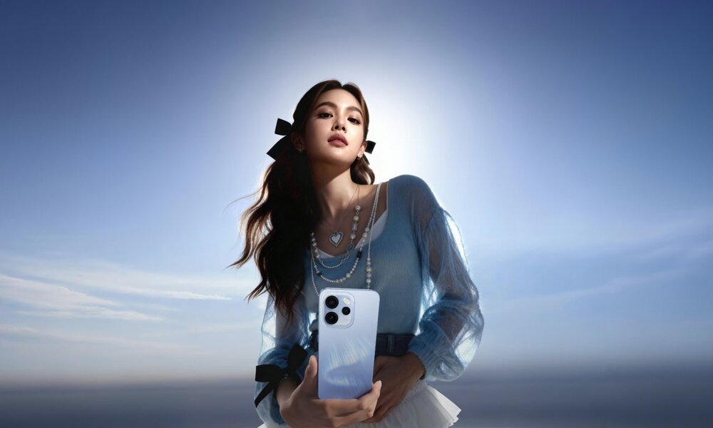 Dziewczyna z kitkami na tle nieba z telefonem w dłoniach