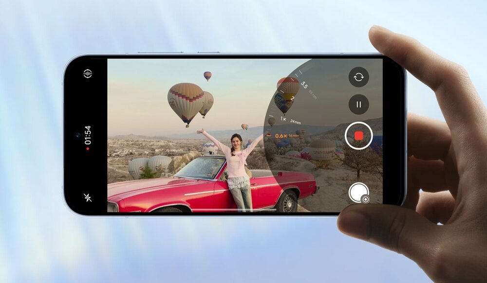 Telefon trzymany w dłoni wyświetlający lecące balony