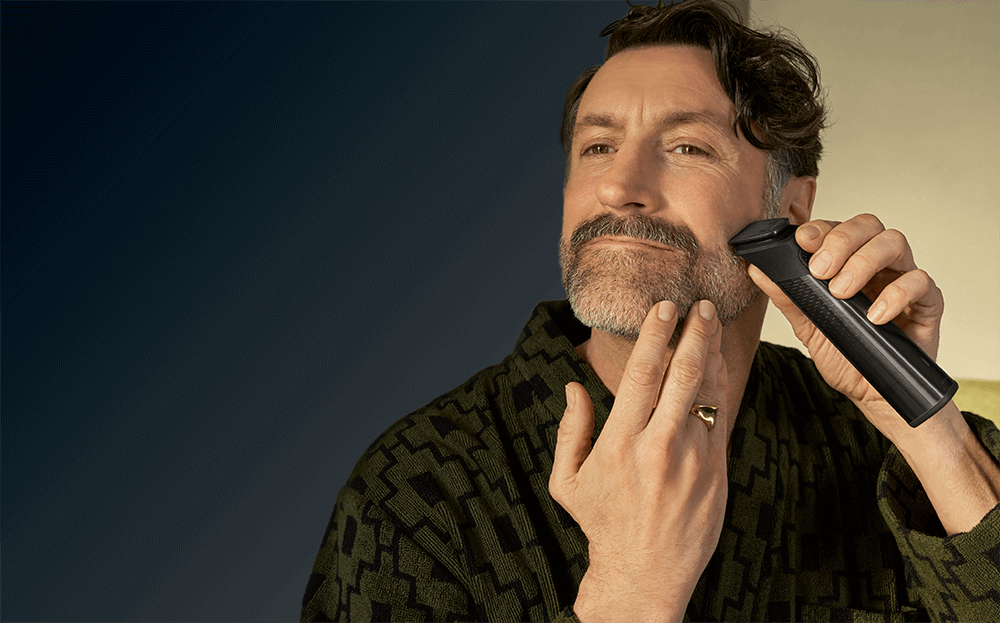 Mężczyzna trzyma w ręce urządzenie multigroom