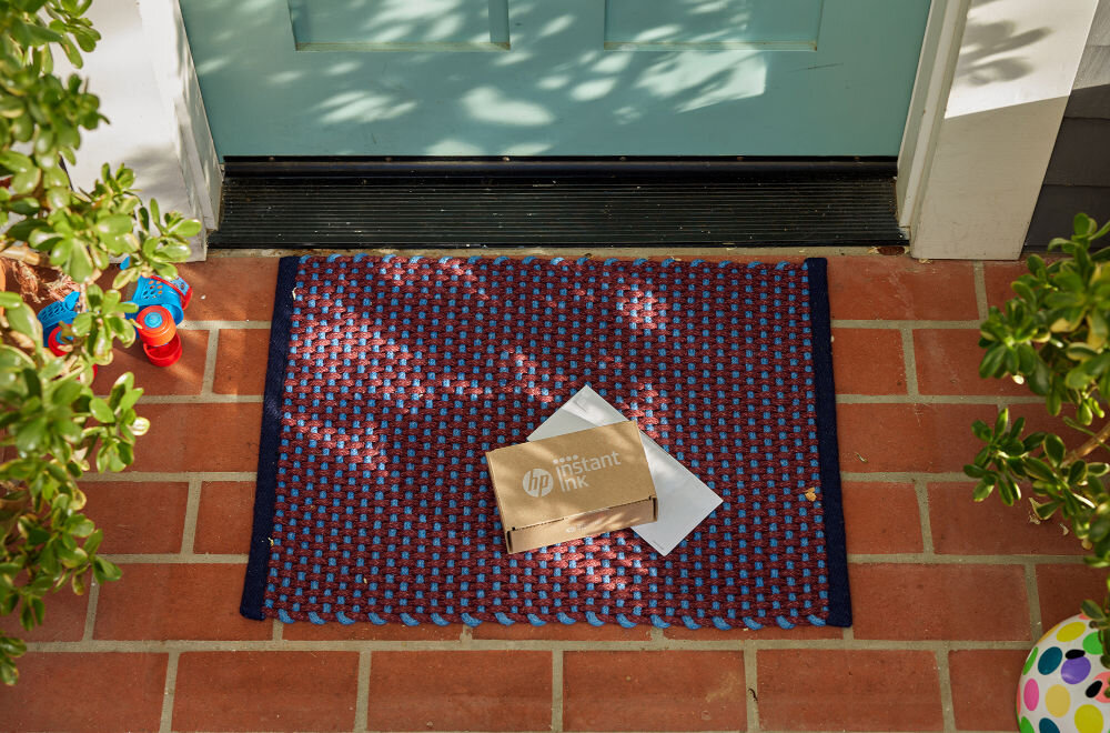 Urządzenie wielofunkcyjne HP DeskJet 2823e Druk w kolorze Wi-Fi paczka z tuszem leżąca na wycieraczce pod drzwiami domu subskrypcja tuszu Instant Ink inteligentne urządzenie dostarczanie tuszu pod drzwi