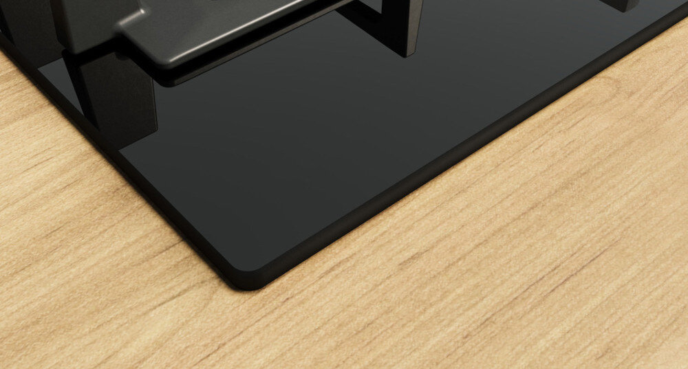 PŁYTA BOSCH PNH6B6K40 Na zdjęciu widać zbliżenie narożnika czarnej, szklanej płyty gazowej osadzonej w jasnym, drewnianym blacie. Wyraźnie widoczna jest gładka, błyszcząca powierzchnia szkła i fragment stabilnego rusztu nad palnikami płyta bezramkowa stylowy design minimalistyczna płyta funkcjonalność łatwe czyszczenie elegancka kuchnia