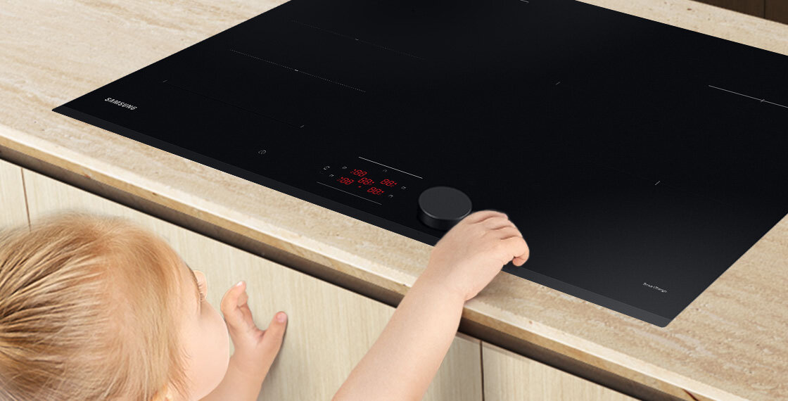 Dziecko sięgające palcem do płyty indukcyjnej Samsung NZ85C6058GK 