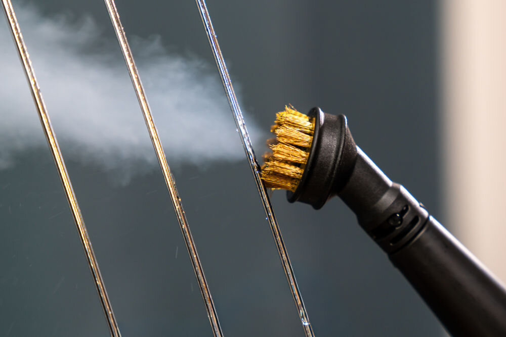 ODKURZACZ PIORĄCY SPOTCLEAN GOTZE&JENSEN CSC600 ze szczotką uniwersalną szeroką do butów do czyszczenia tapicerki meblowej samochodowej dywanów Bardzo bliskie ujęcie okrągłej szczotki parowej z mosiężnym włosiem, czyszczącej metalowe pręty (np. rusztu, grzejnika). Wydobywająca się para jest dobrze widoczna.