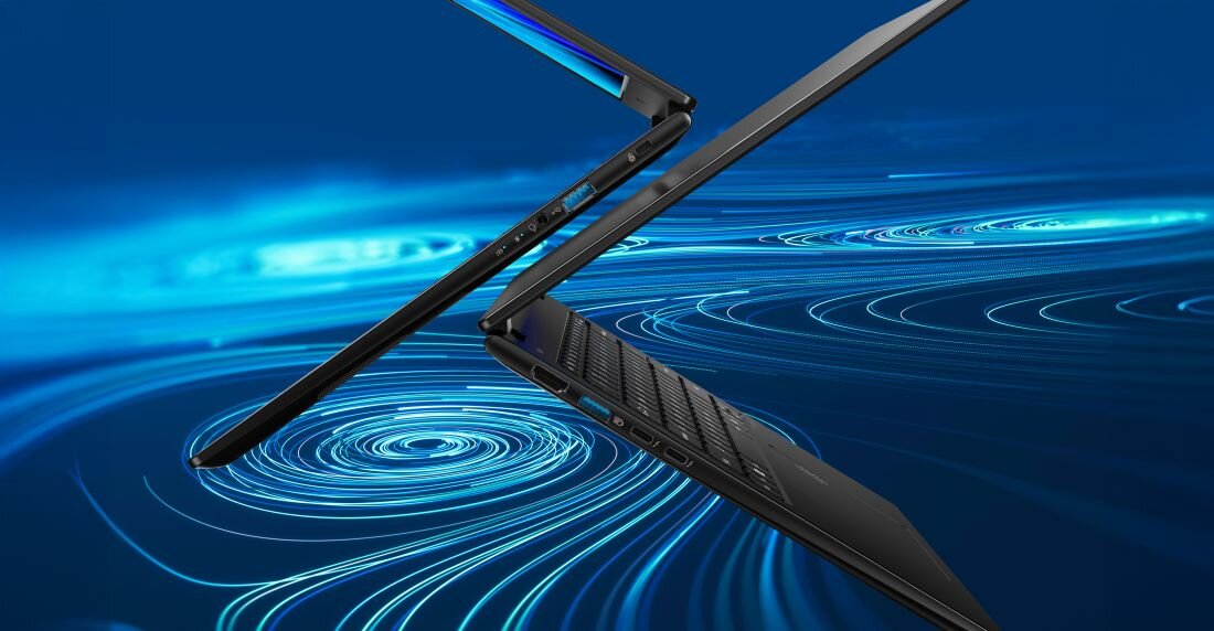 Dwa laptopy w ciemnym kolorze są otwarte i ustawione w pozycji przypominającej literę \'V\' na tle niebieskich, wirujących wzorów. Na obudowie widoczne są porty i złącza.