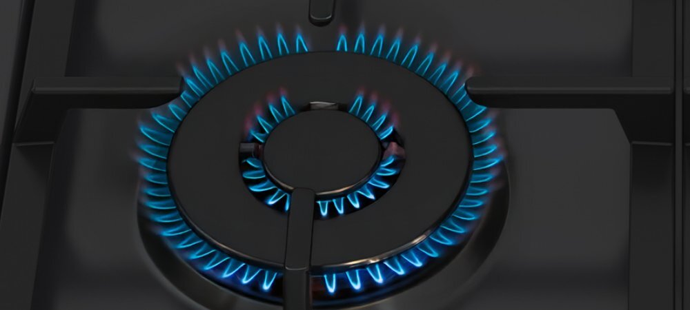 KUCHNIA WHIRLPOOL W5G8LMSWTB Kadr przedstawia czarny ruszt i pojedynczy okrągły palnik gazowy, z którego równo rozchodzi się niebieski płomień w dwóch pierścieniach. Obraz podkreśla moc i równomierne rozprowadzenie ognia palnik WOK mocny płomień wysoka temperatura szybkie smażenie stir fry chrupkość aromat równomierne grzanie pełnia smaku