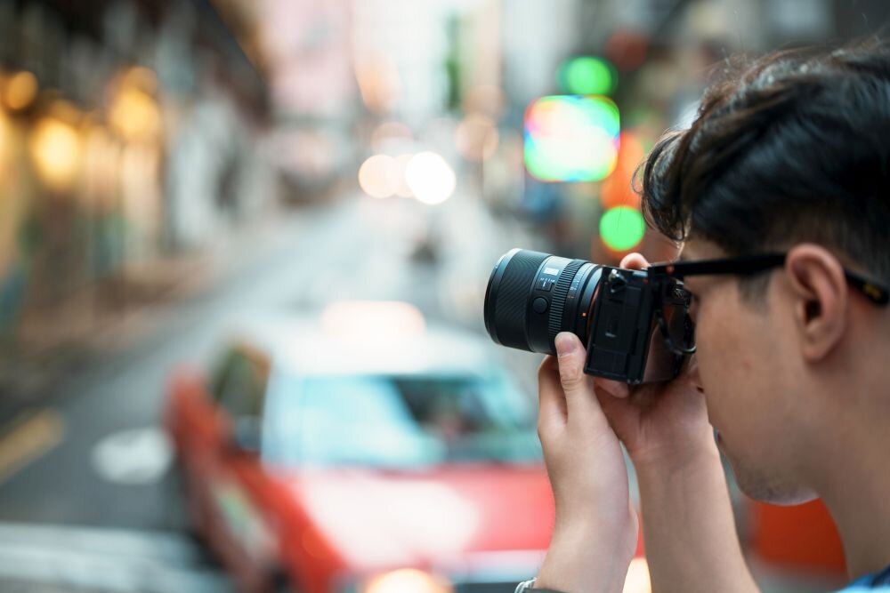 Viltrox AF 85 mm f-2.0 Evo lekki obiektyw 360g kompaktowy gwint 58mm mobilna fotografia człowiek robi zdjęcie aparatem 