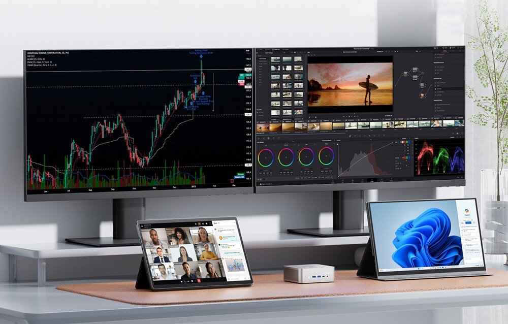 Komputer MINISFORUM M1 PRO-285H Stanowisko pracy z dwoma szerokimi monitorami pokazującymi wykres giełdowy i program do edycji wideo oraz tablet i laptop na biurku