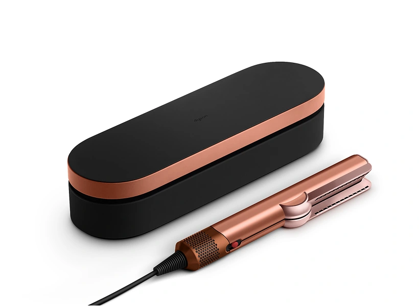 Etui prezentowe i prostownica Dyson Airstrait leżą na blacie.