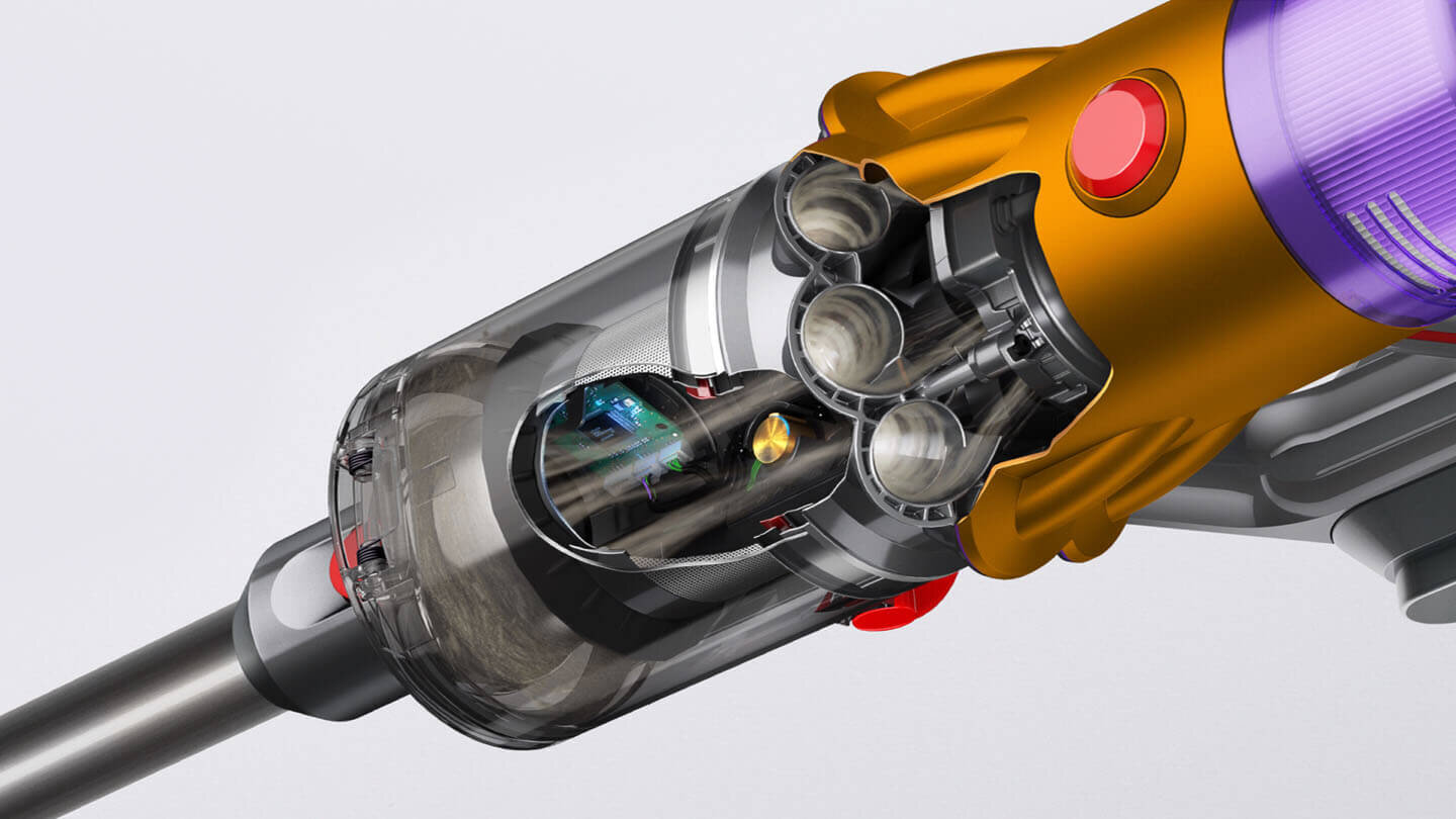 Zbliżenie na przezroczysty pojemnik odkurzacza z widocznymi elementami wewnętrznymi. Obudowa jest w kolorach złotym i fioletowym z czerwonym przyciskiem.