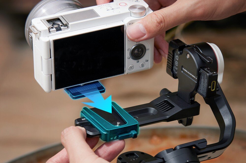 Gimbal ZHIYUN Crane M3S osoba montująca aparat na gimbalu ze strzałką przedstawiającą kierunek wkładania montaż szybkozłączka
