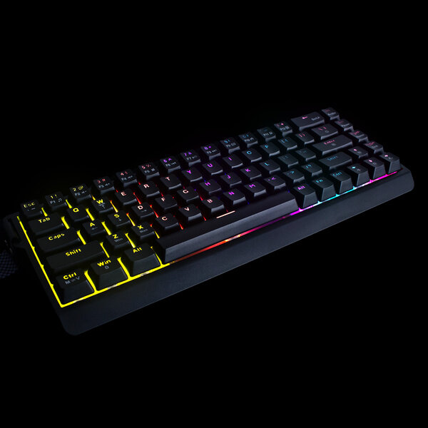 Czarna klawiatura mechaniczna z podświetleniem RGB, widoczna na ciemnym tle. Klawisze są podświetlone w różnych kolorach, tworząc efekt tęczy.