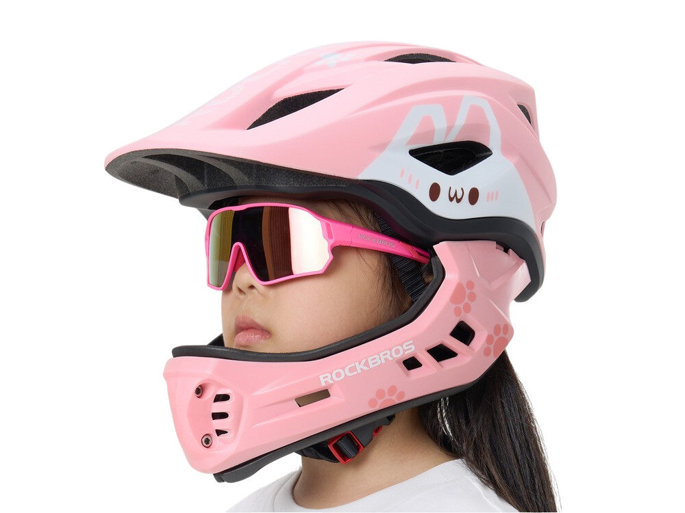 Kask rowerowy ROCKBROS TT-32002 Rabbit Różowy Full Face dla Dzieci z odkręcaną szczęką (rozmiar M), fullface, ochrona, eps, bezpieczeństwo, Dziecko w różowym kasku i okularach patrzy w bok.