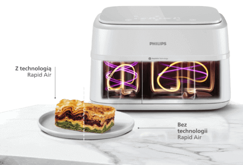 Na obrazie widoczna jest frytkownica beztłuszczowa marki PHILIPS z dwoma koszami, obok której znajduje się talerz z kawałkiem lasagne. Na frytkownicy widnieje napis \'2 technologie Rapid Air\', a przy talerzu \'Bez technologii Rapid Air\'.