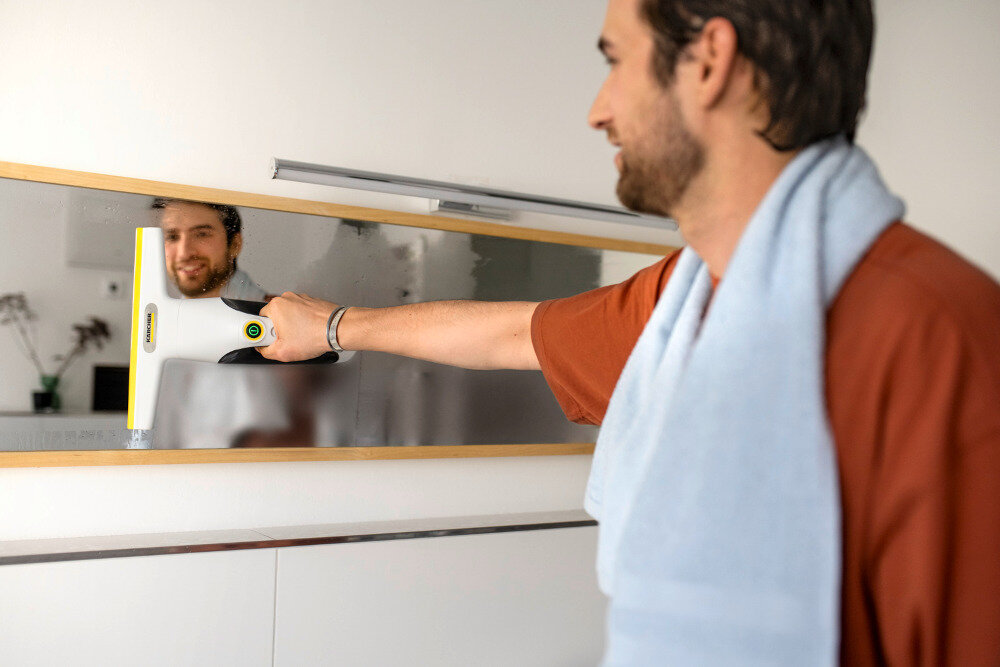 Myjka do okien KARCHER WV 2 Universal Care 1.633-671.0 Odsysanie wody system odsysania eliminuje zacieki, kapanie i smugi na czyszczonych powierzchniach osoba użytkuje myjkę na lustrze