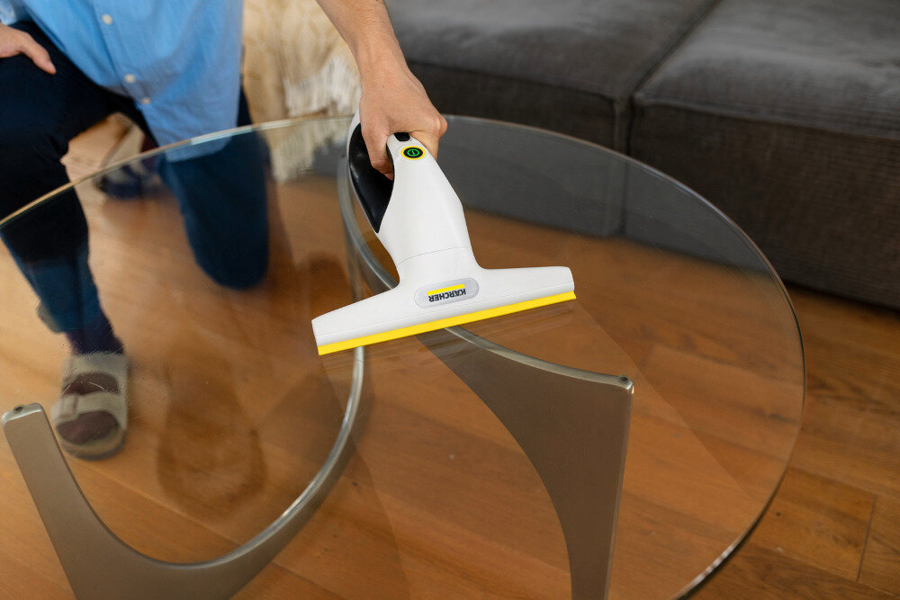 Myjka do okien KARCHER WV 2 Universal Care 1.633-671.0 Higiena użytkowania Zbiornik na brudną wodę o pojemności 120 ml port USB-C osoba użytkuje myjkę na szklanym stoliku