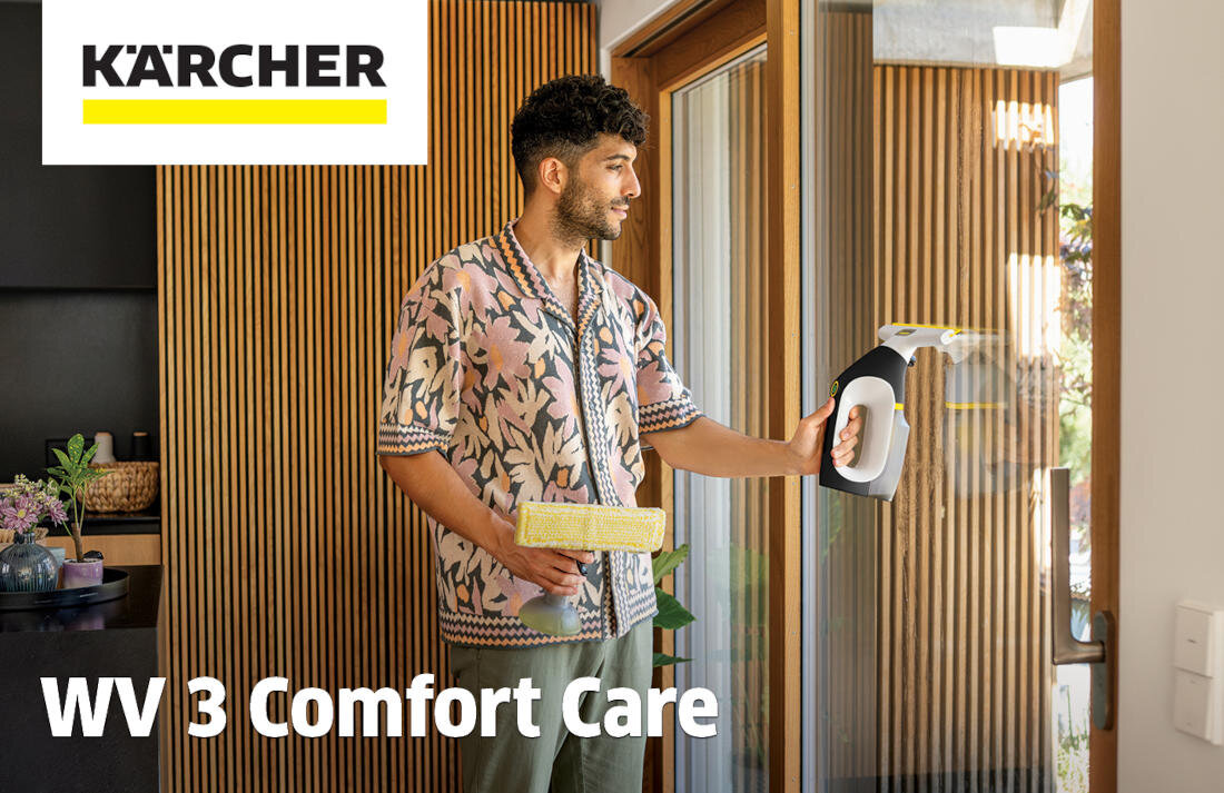 Osoba trzyma myjkę do okien KARCHER WV 3 Comfort Care przy szklanych drzwiach. W tle widoczne są drewniane panele i rośliny, a na obrazie znajduje się logo KARCHER oraz tekst \'WV 3 Comfort Care\'.