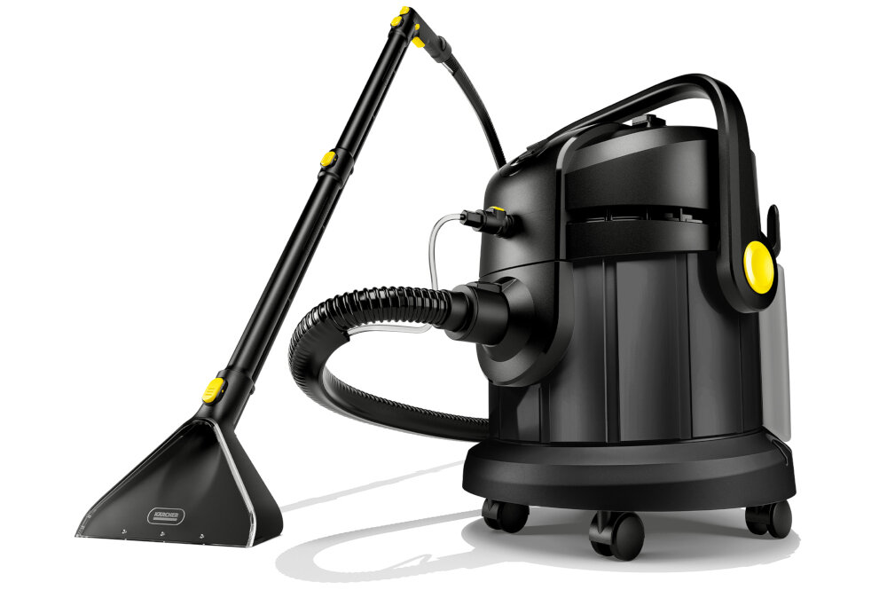 Czarny odkurzacz piorący z żółtymi elementami, wyposażony w długi wąż i szeroką ssawkę. Na ssawce widoczne jest logo \'KARCHER\'.