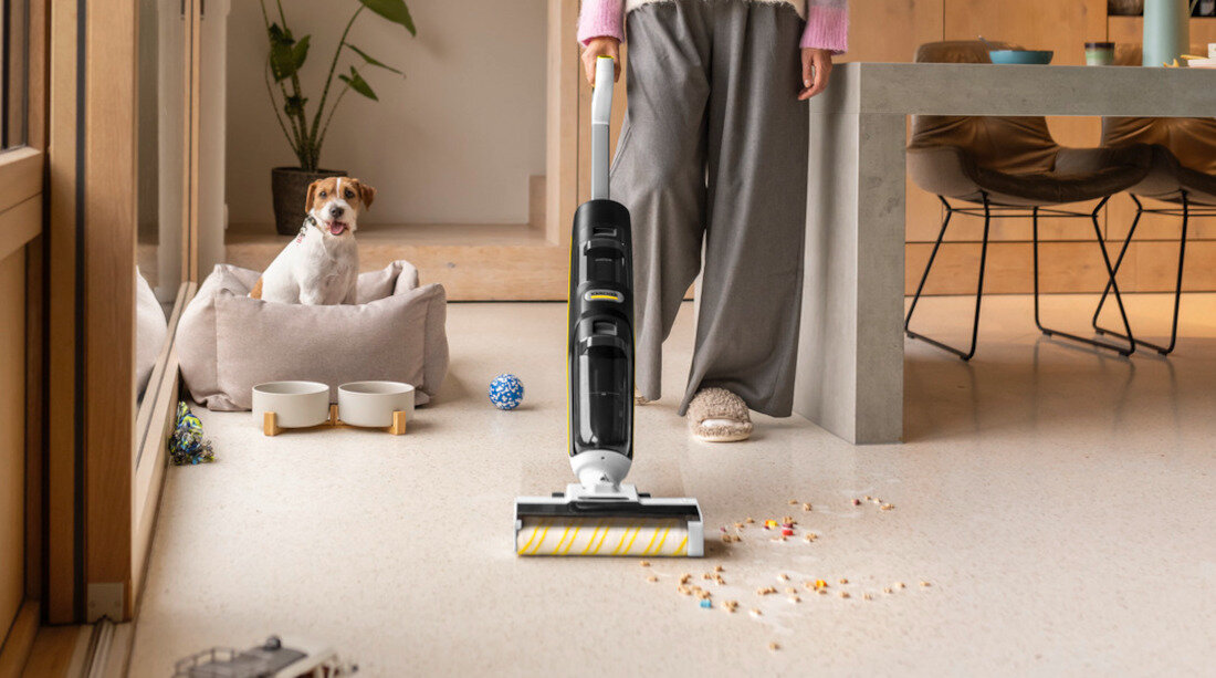 Mop elektryczny KARCHER FCV 4 Pet & Home Dry 1.056-137.0 dla właścicieli zwierząt zbiera sierść usuwa ślady pozostawione przez zwierzęta zbliżenie osoba czyści podłogę pies siedzi w legowisku