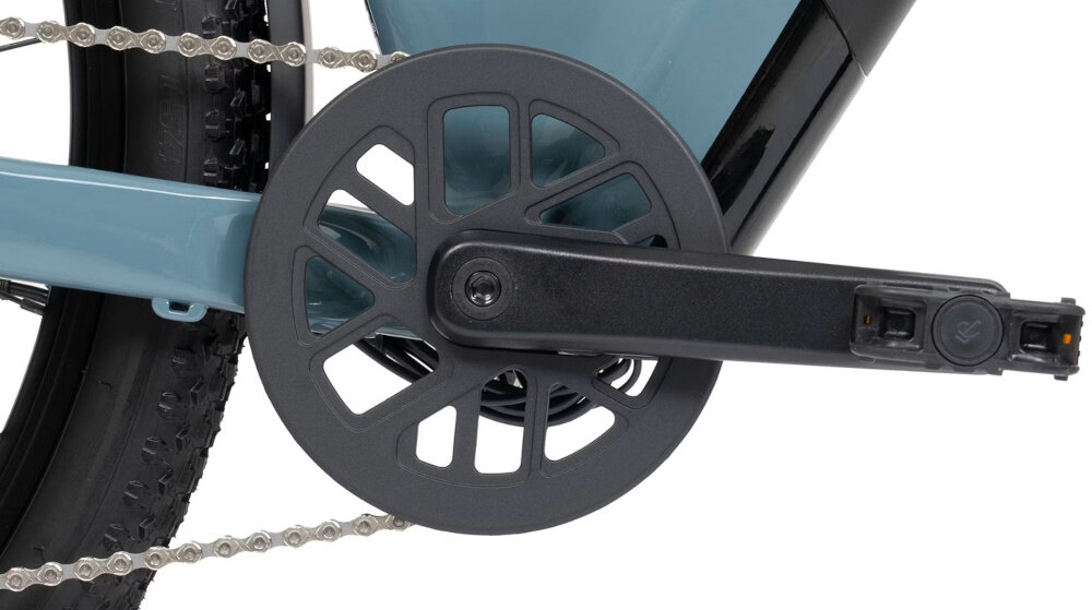 Rower elektryczny ROMET E-Modeco SUV 1.0 AN D U17 28 cali Szary zbliżenie na korbę i kasetę korba PROWHEEL typu 38T o długości 170 mm kaseta SHIMANO CUES typu CS-LG300-9 płynna i elastyczna jazda szeroki zakres przełożeń komfortowa kadencja na prostych odcinkach lepsza kontrola nad rowerem większa efektywność pedałowania