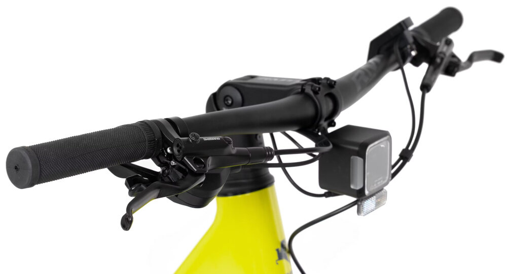 Zbliżenie na kierownicę roweru elektrycznego w kolorze limonkowym z widocznymi manetkami i wyświetlaczem. Na ramie znajduje się logo \'ROMET\'.