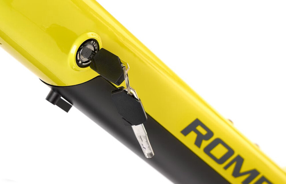 Zbliżenie na ramę roweru w kolorze limonkowym z widocznym zamkiem i kluczykiem. Na ramie znajduje się napis \'ROMET\'.