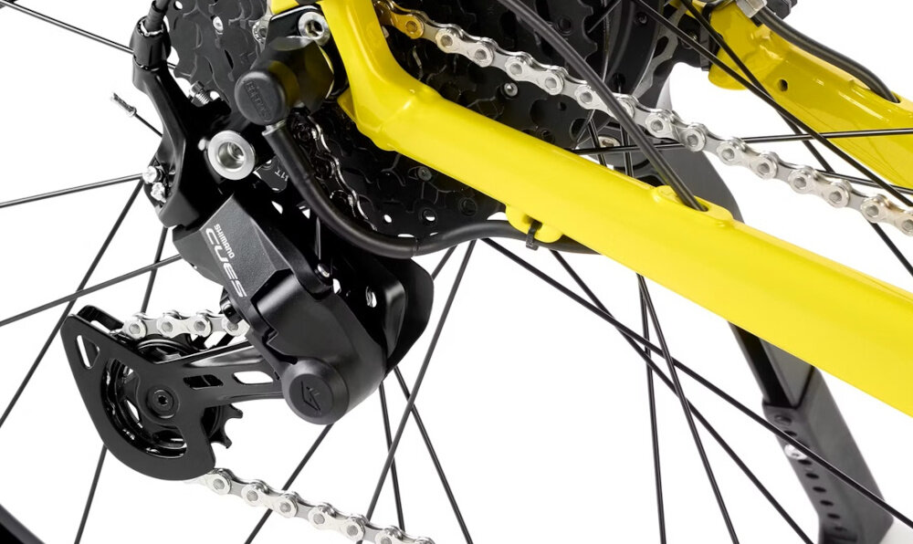 Zbliżenie na tylną przerzutkę roweru z widocznym mechanizmem łańcucha i zębatek. Rama roweru jest w kolorze limonkowym.