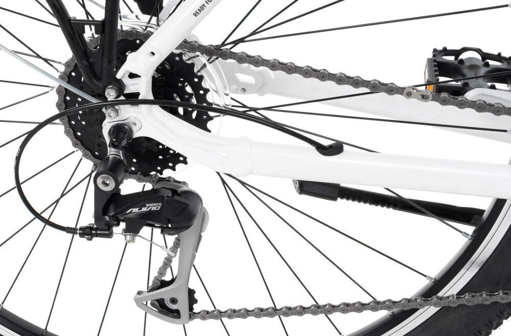 Zdjęcie przedstawia tylną część roweru z widocznym mechanizmem przerzutki i łańcuchem. Na przerzutce widoczny jest napis \'SHIMANO ALIVIO\'.