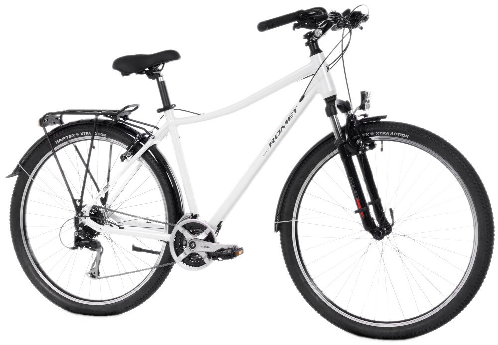 Biały rower trekkingowy z czarnymi elementami, wyposażony w bagażnik, amortyzator przedni i opony z napisem \'HARTEX XTRA ACTION\'. Na ramie widoczne jest logo \'ROMET\'.