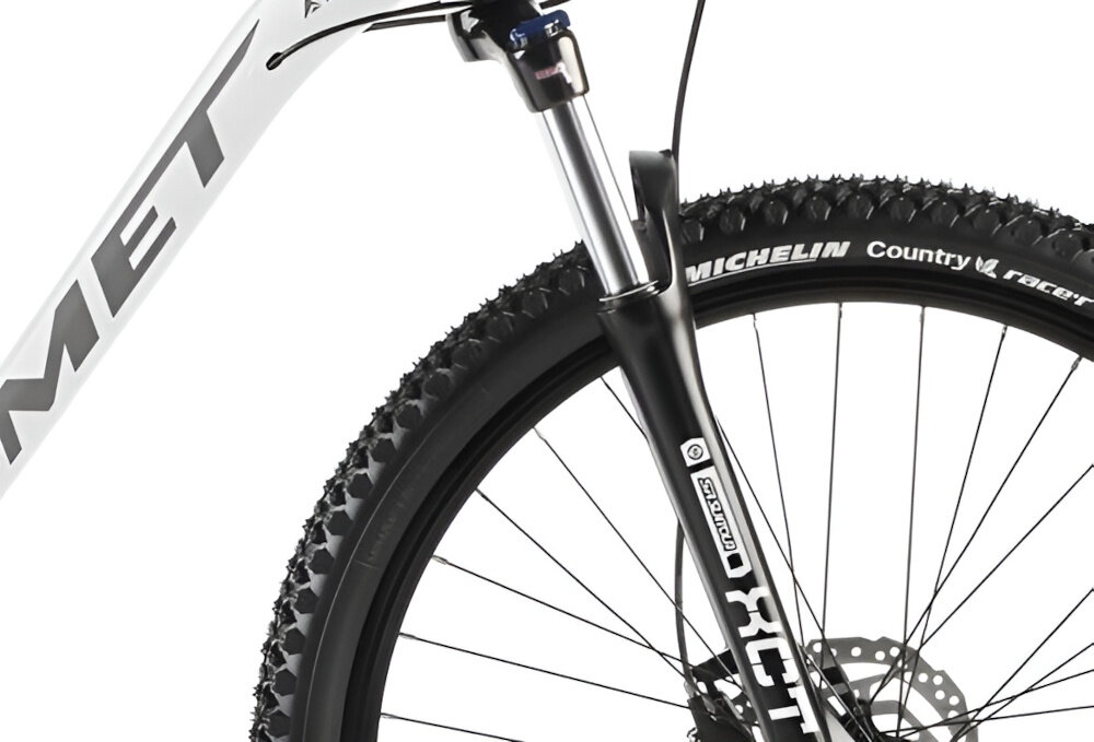 Rower górski MTB ROMET Rambler R7.3 U20 27.5 cala Biało-złoty zbliżenie na amortyzator widok z góry rower typu hardtail przedni amortyzator SUNTOUR typu SR XCT DS HLO ze skokiem 100 mm ułatwia najeżdżanie na przeszkody niweluje wstrząsy niska masa roweru duża sztywność regulacja za pomocą sprężyny obsługa poprzez manetkę