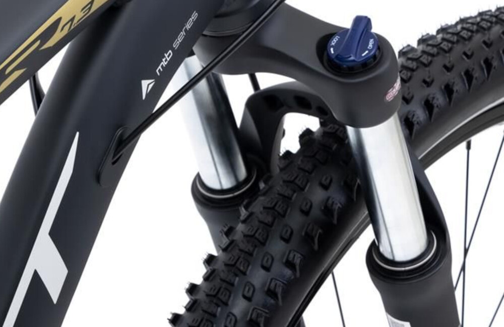 Rower górski MTB ROMET Rambler R7.3 U18 27.5 cali Czarno-złoty zbliżenie na amortyzator rower typu hardtail przedni amortyzator SUNTOUR typu SF-19 XCT-DS-HL ułatwia najeżdżanie na przeszkody niweluje wstrząsy niska masa roweru duża sztywność regulacja za pomocą sprężyny obsługa poprzez manetkę