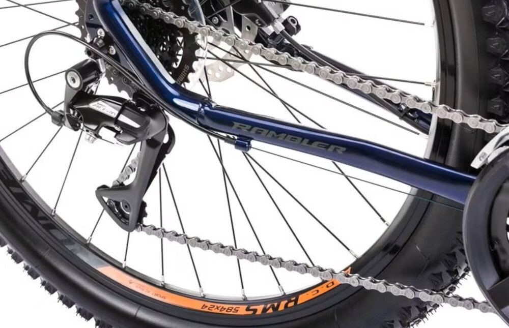 Rower górski MTB ROMET Rambler R7.3 U18 27.5 cali Granatowo-pomarańczowy zbliżenie na tylną przerzutkę przerzutki marki SHIMANO 24 biegi duża wytrzymałość i sprawne działanie zmiana biegów jest płynna i bezproblemowa przednia przerzutka SHIMANO Tourney tylna 9-rzędowa SHIMANO Alivio ciche działanie