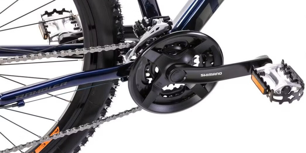 Rower górski MTB ROMET Rambler R7.3 U18 27.5 cali Granatowo-pomarańczowy zbliżenie na korbę do wszechstronnej jazdy terenowej i rekreacyjnej kaseta SHIMANO typu HG-31 11-34 8SP korba marki SHIMANO typu FC-TY301 płynna zmiana przełożeń łatwe dopasowanie siły pedałowania do warunków terenu