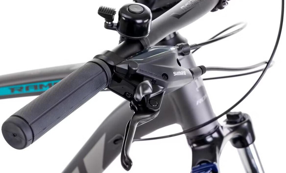 Rower górski MTB ROMET Rambler R7.4 A U20 27.5 cala Grafitowo-srebrno-turkusowy zbliżenie na jeden z uchwytów widoczny dzwonek białe tło antypoślizgowe uchwyty stabilny i pewny chwyt kierownicy ograniczają ślizganie się dłoni lepsza kontrola nad rowerem większy komfort podczas jazdy bezpieczeństwo dzwonek szybkie i skuteczne ostrzeganie innych uczestników ruchu pozwala lepiej komunikować swoją obecność