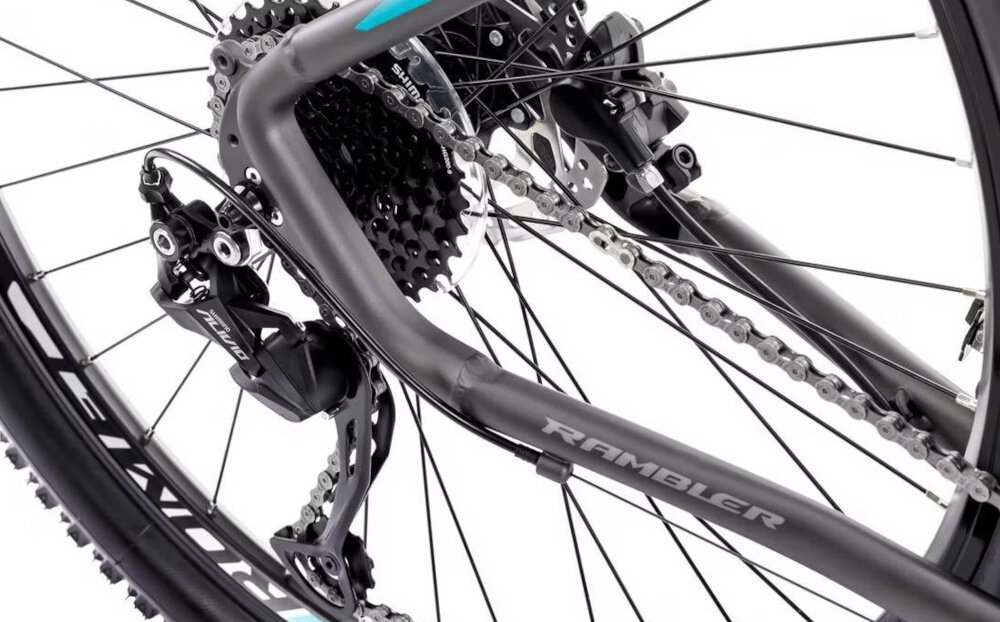 Rower górski MTB ROMET Rambler R7.4 A U20 27.5 cala Grafitowo-srebrno-turkusowy zbliżenie na tylną przerzutkę przerzutki marki SHIMANO 8 przełożeń duża wytrzymałość sprawne działanie zmiana biegów jest płynna i bezproblemowa przednie przerzutki SHIMANO Altus z technologią SHADOW przerzutka jest schowana i mniej narażona na uszkodzenia tylne przerzutki SHIMANO Alivio precyzyjna praca mechanizmu komfort i kontrola