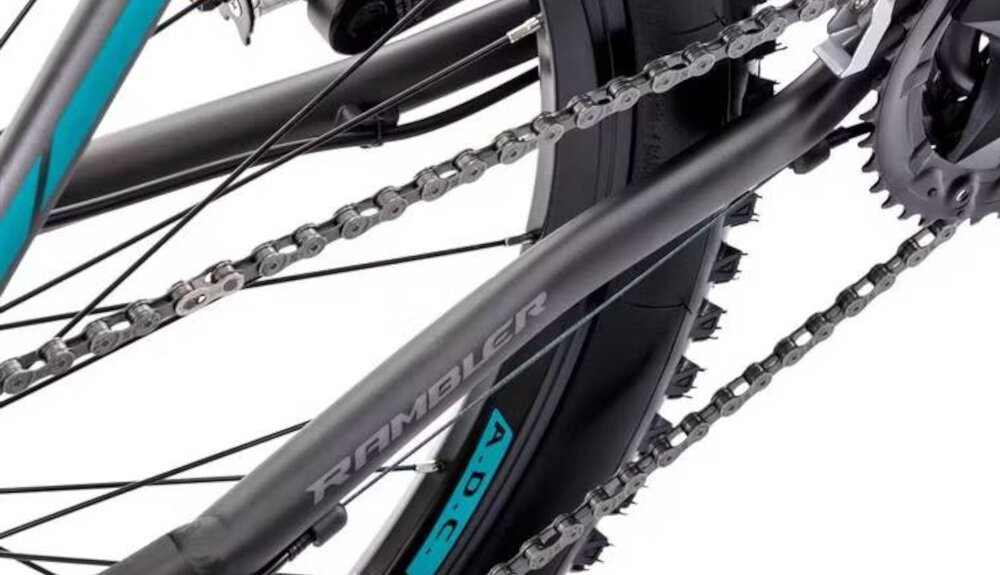 Rower górski MTB ROMET Rambler R7.4 A U20 27.5 cala Grafitowo-srebrno-turkusowy zbliżenie na łańcuch stalowy łańcuch marki ROMET odpowiednia konstrukcja ogniw wspiera płynną współpracę z kasetą i zębatkami bardziej równomierne przenoszenie mocy mniejsze zużycie pozostałych elementów napędu