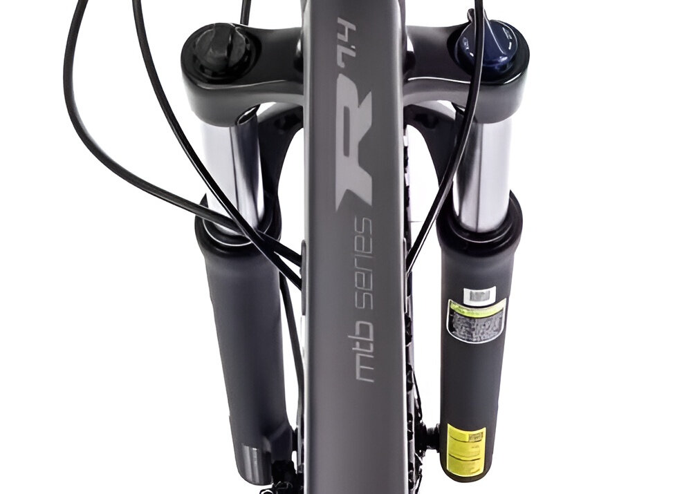 Rower górski MTB ROMET Rambler R7.4 A U20 27.5 cala Grafitowo-srebrno-turkusowy zbliżenie na amortyzator widok z góry białe tło rower typu hardtail przedni amortyzator marki Suntour typu XCT HLO ze skokiem 100 mm skutecznie tłumi drgania i wstrząsy płynna i stabilna jazda amortyzator poprawia przyczepność kół kontrola nad rowerem wyższy poziom bezpieczeństwa i komfortu jazdy