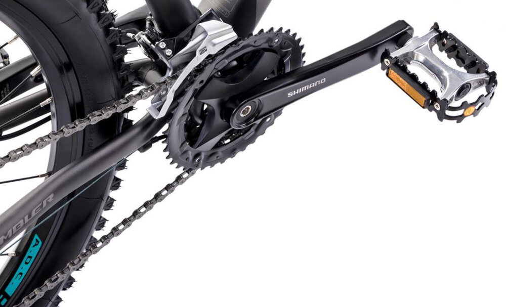 Rower górski MTB ROMET Rambler R7.4 C U18 27.5 cala Grafitowo-srebrno-turkusowy zbliżenie na korbę do wszechstronnej jazdy terenowej i rekreacyjnej 9-rzędowa kaseta SHIMANO typu CS-HG200 11–34T korba marki SHIMANO typu FC-MT101, 40/30/22T 175 mm płynna zmiana przełożeń łatwe dopasowanie siły pedałowania do warunków terenu